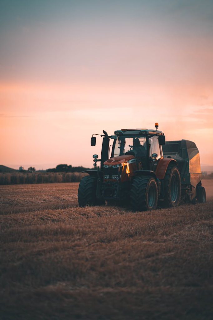Tractor working in a Wiesbaden field during a picturesque sunset with ample copy space.
